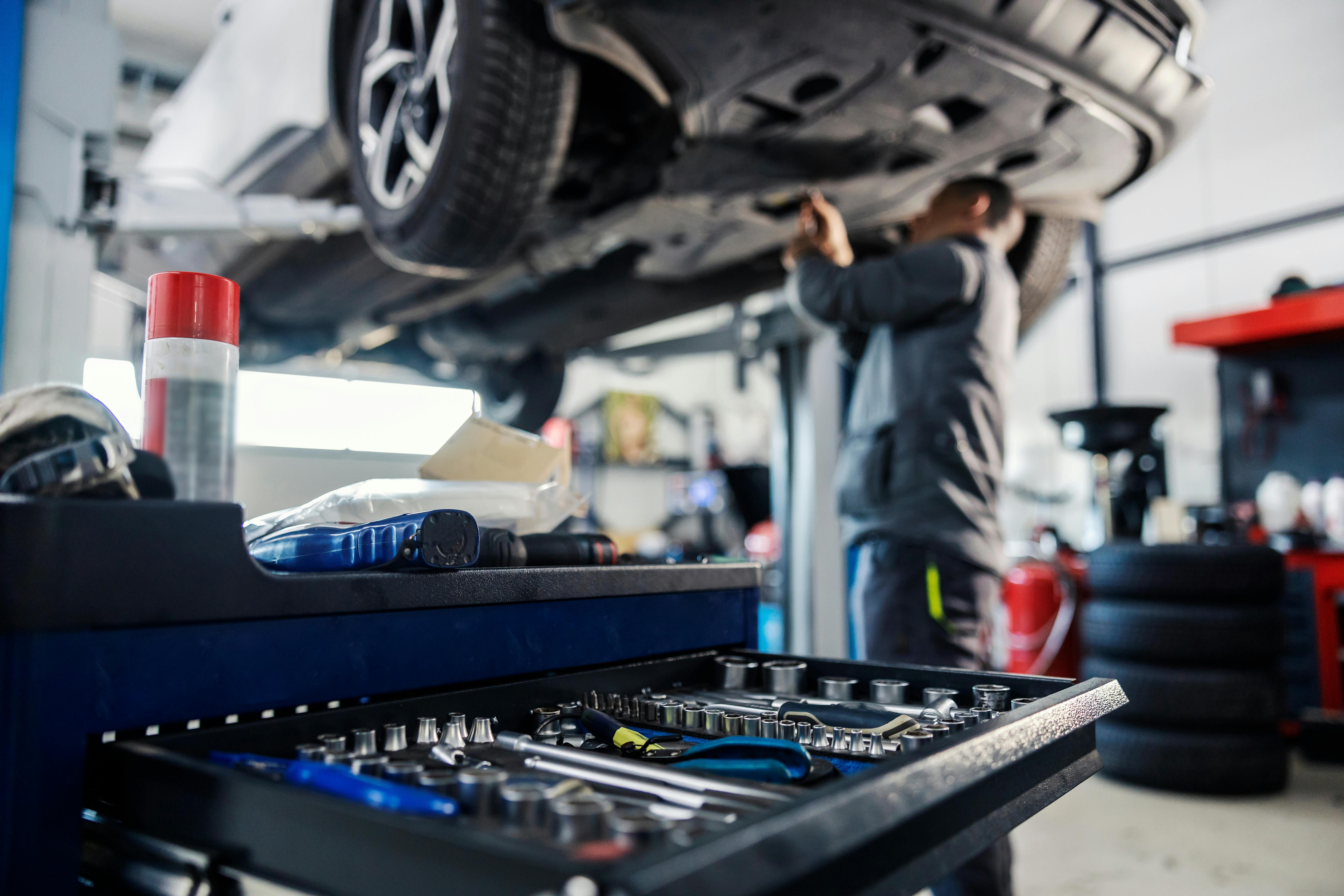 Close up of Arrow Motors technician inspecting brakes and wheels