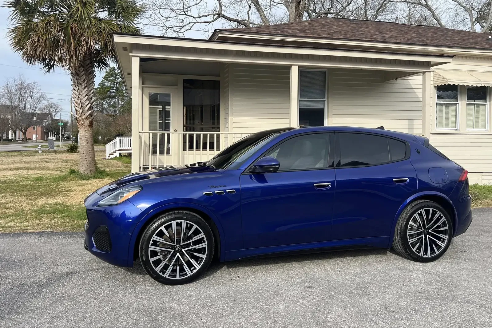 Side view of a blue Maserati SUV with tinted windows outside Coastal Glass Tinting