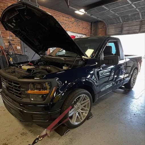 Performance car strapped on a chassis dyno for tuning pulls
