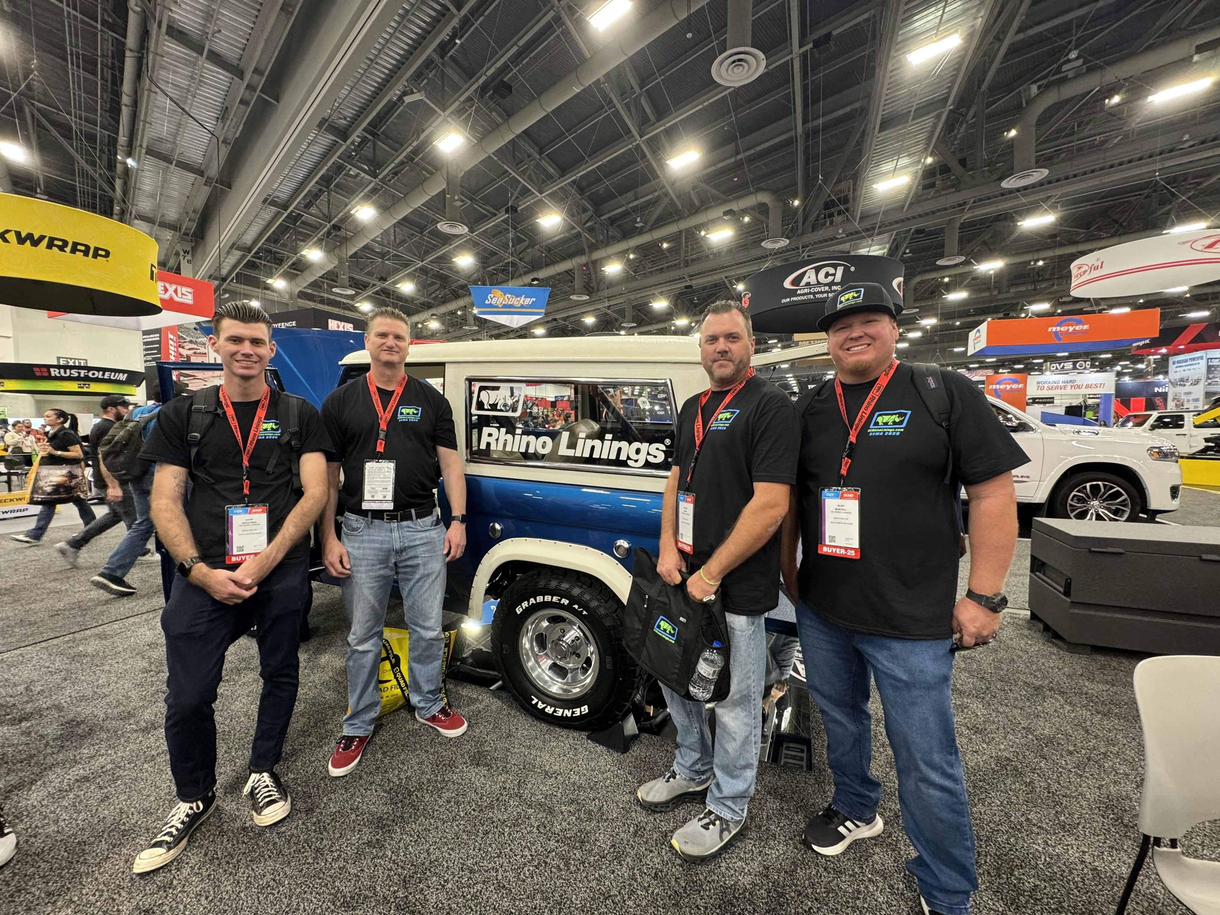 A group of men standing in a room with a truckAI-generated content may be incorrect.