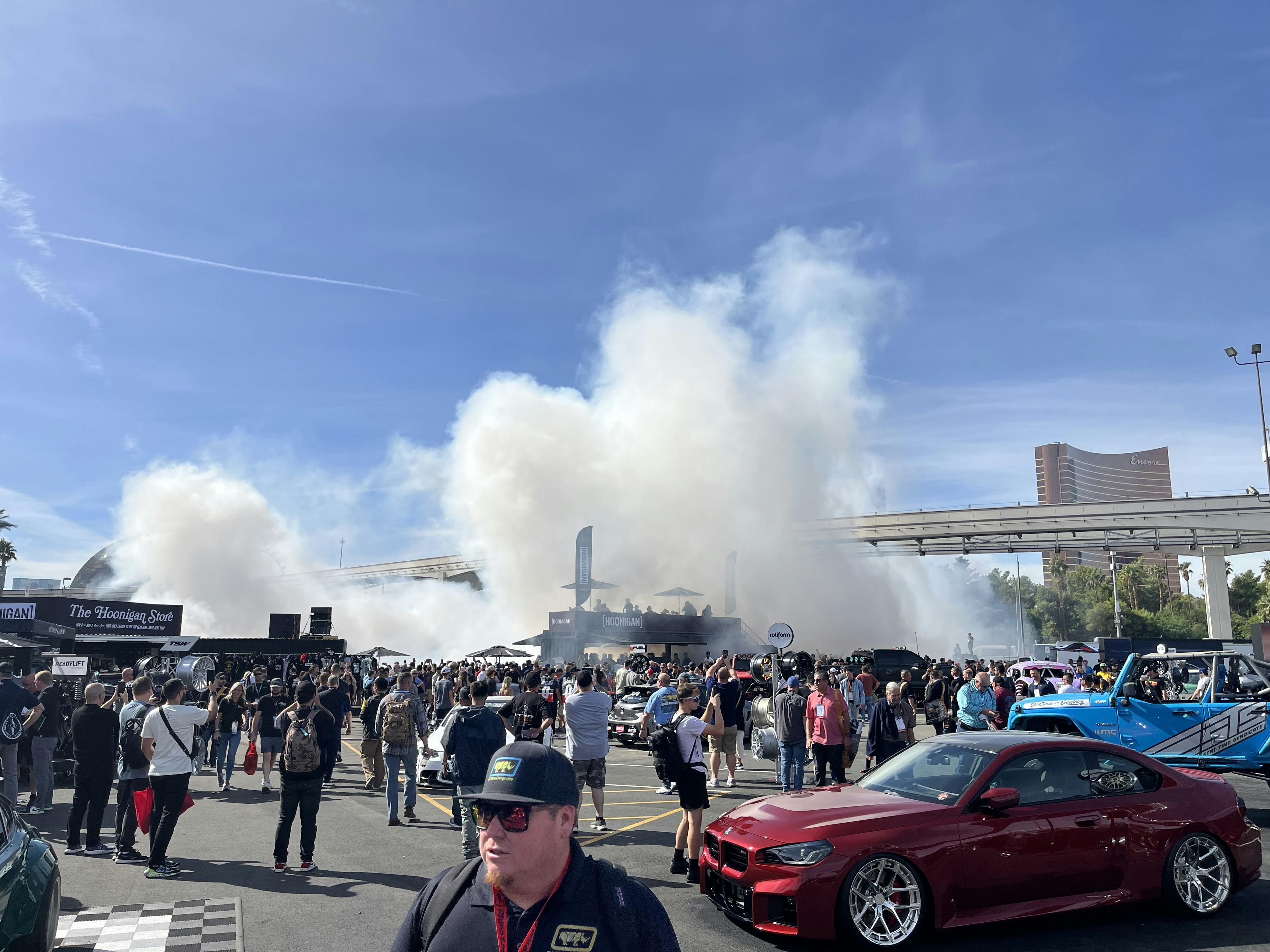 A group of people in a parking lot with cars and smokeAI-generated content may be incorrect.