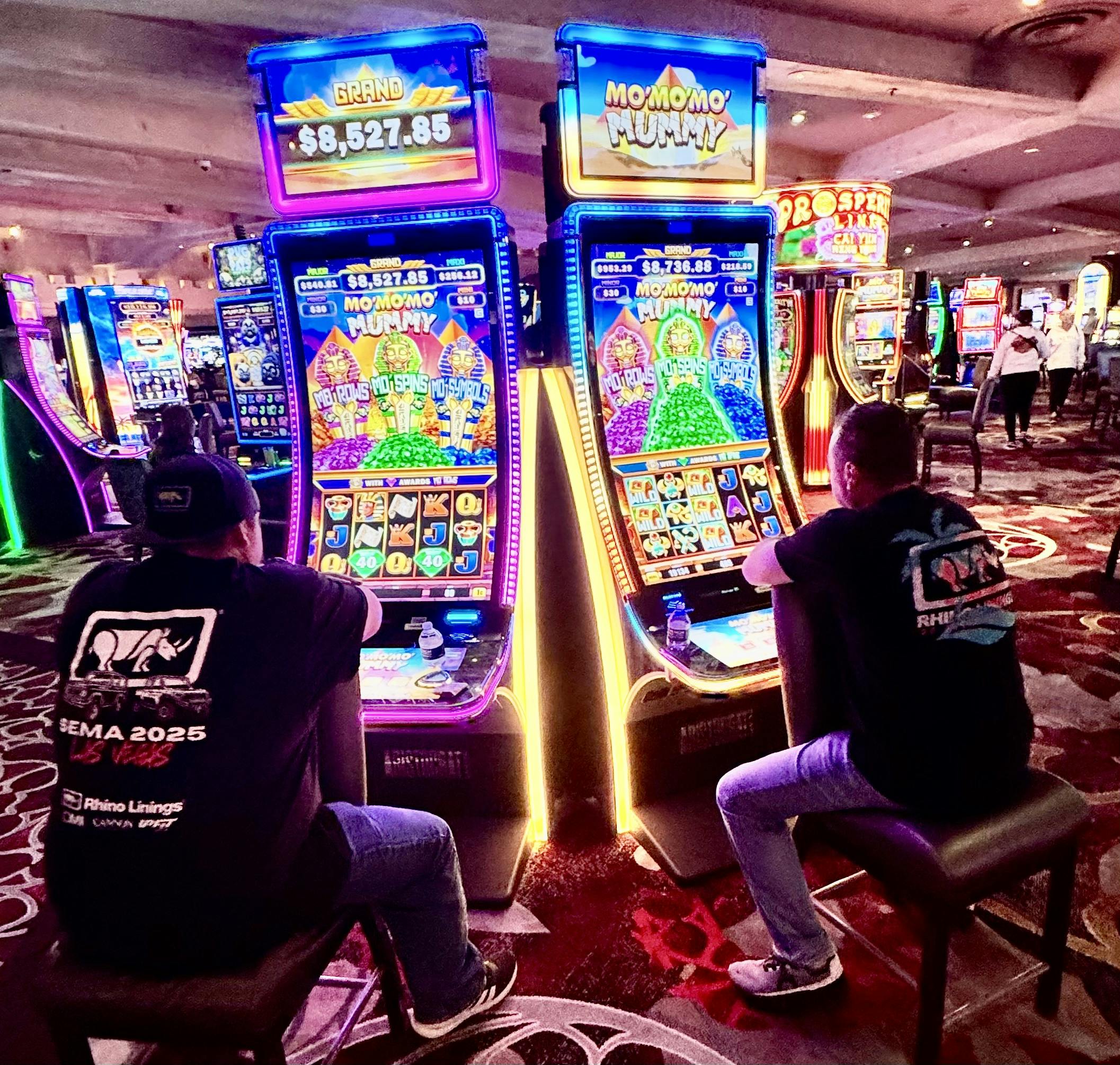 A group of people playing slot machinesAI-generated content may be incorrect.